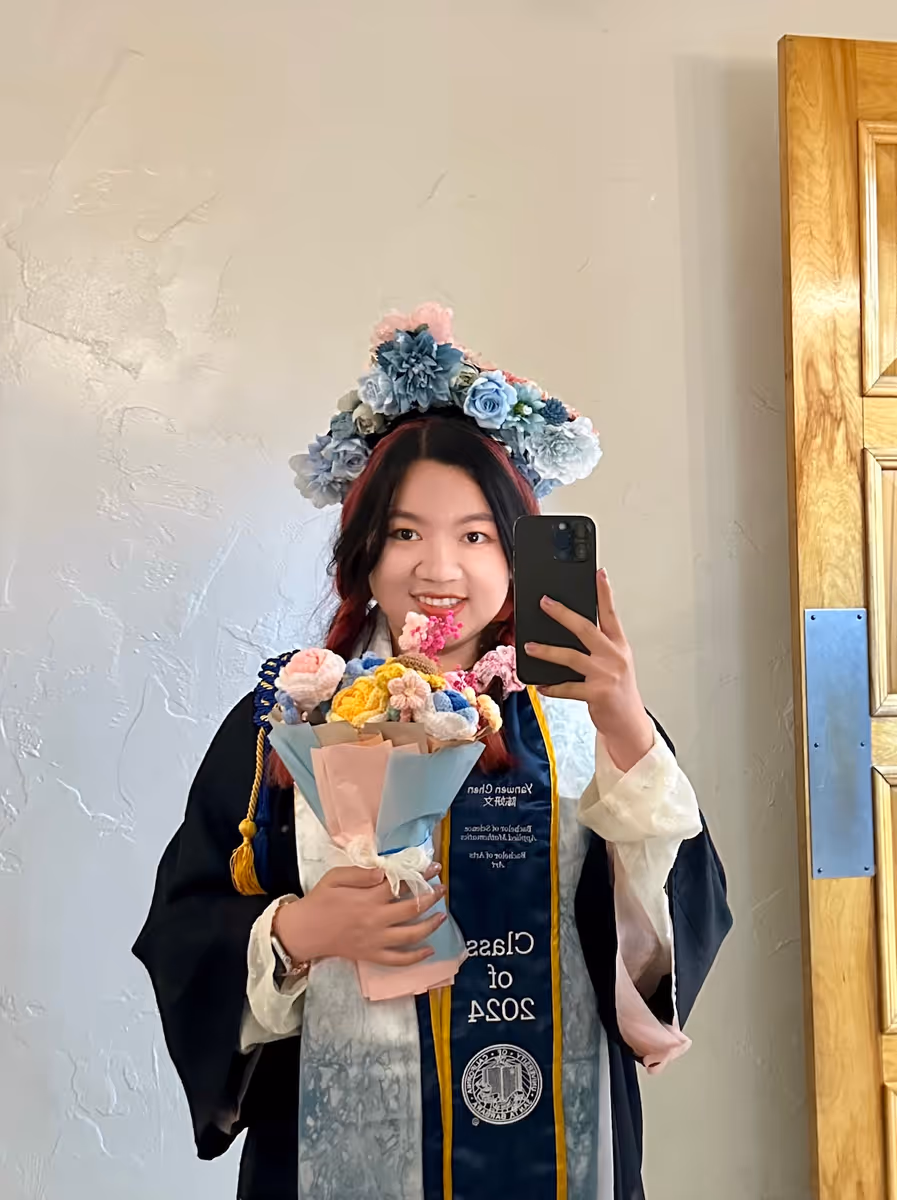 Graduation day selfie in cap and gown with a floral crown